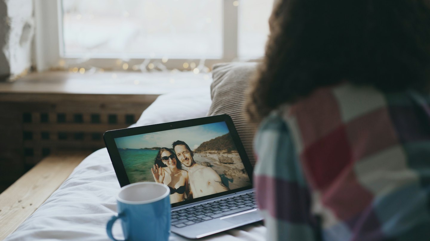 Person betrachtet ein Paarfoto auf ihrem Laptop-Bildschirm.